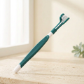 Brosse Quenott vert foncé et blanc sur fond crème lumineux
